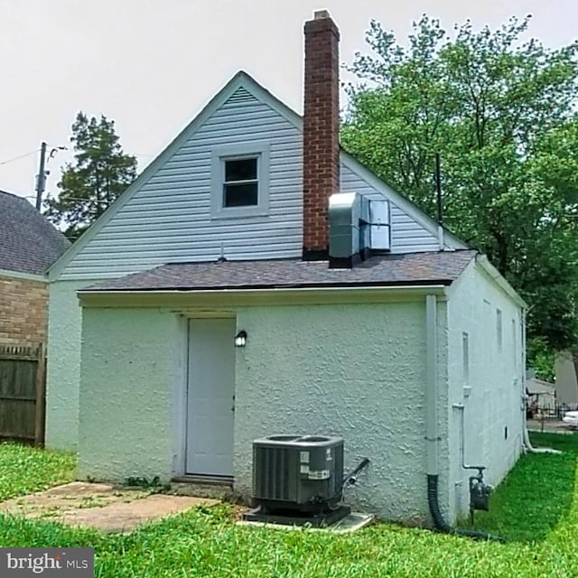 509 Cedarleaf Ave, Capitol Heights, MD 20743 - back of house with central air condition unit, stucco siding, a chimney, and a shingled roof