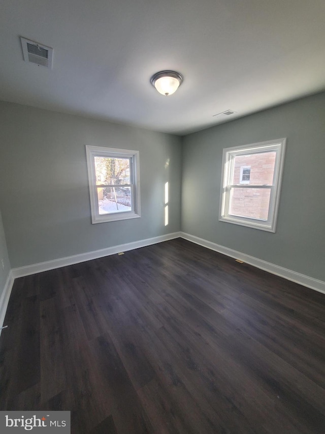 unfurnished room with dark hardwood / wood-style flooring