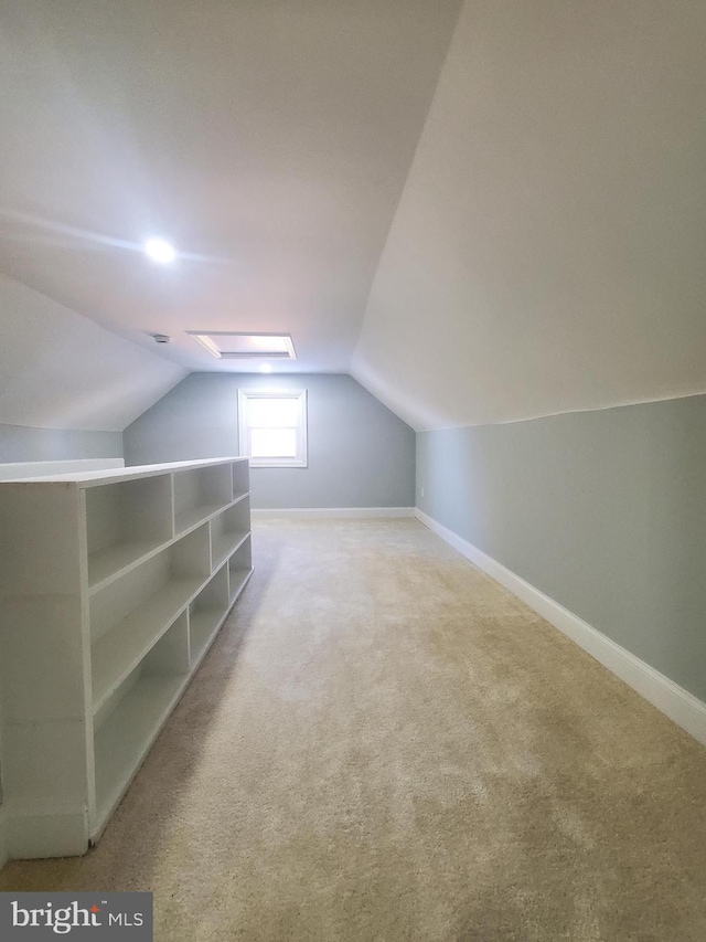 bonus room with vaulted ceiling and carpet flooring