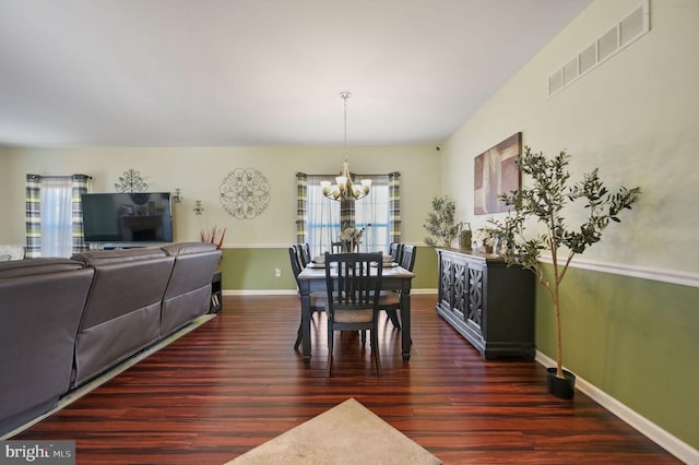 dining area featuring a notable chandelier and dark hardwood / wood-style floors