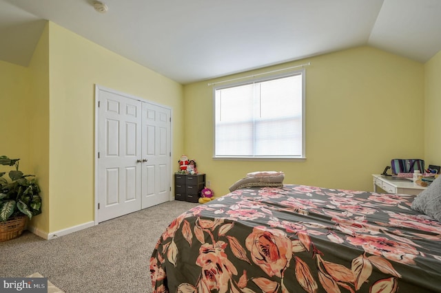 carpeted bedroom featuring vaulted ceiling and a closet