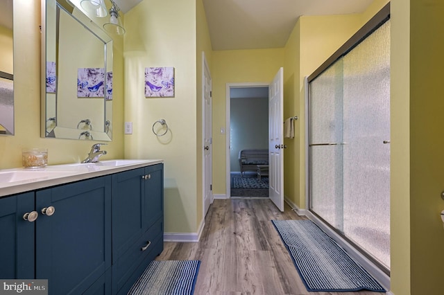 bathroom featuring hardwood / wood-style flooring, vanity, and an enclosed shower