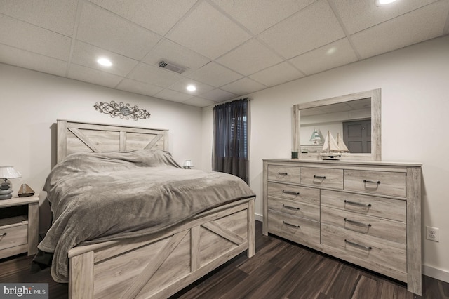 bedroom with a paneled ceiling and dark hardwood / wood-style floors