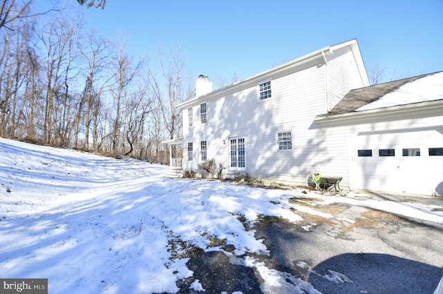 snow covered property featuring a garage