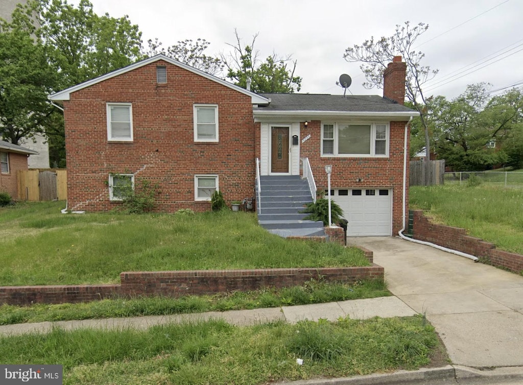 tri-level home featuring a front yard and a garage