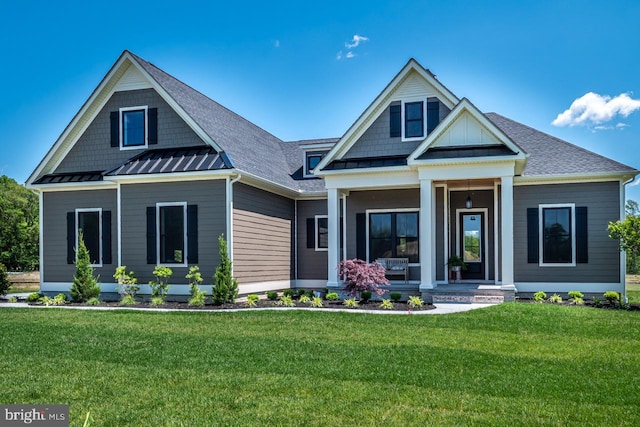 craftsman inspired home featuring a standing seam roof, metal roof, a front lawn, and covered porch