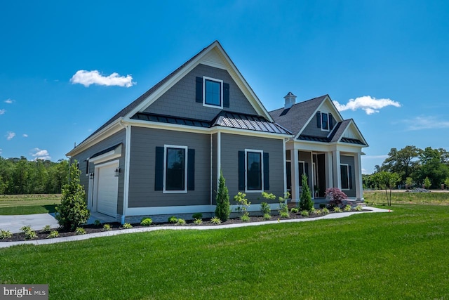 view of front facade with a garage, metal roof, a standing seam roof, and a front yard