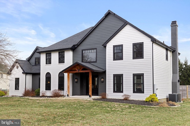 view of front of home with central air condition unit, a patio, and a front lawn