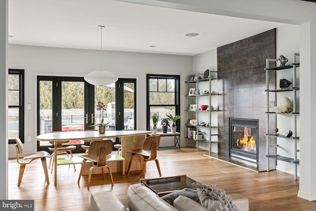 dining room featuring light hardwood / wood-style flooring, french doors, and a fireplace