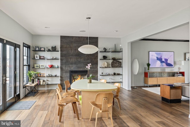 dining area featuring wood-type flooring and a fireplace