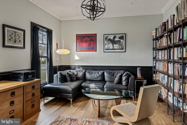 living room featuring light hardwood / wood-style floors, an inviting chandelier, and ornamental molding