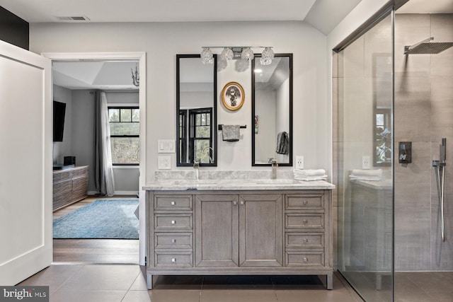 bathroom with walk in shower, tile patterned floors, and vanity