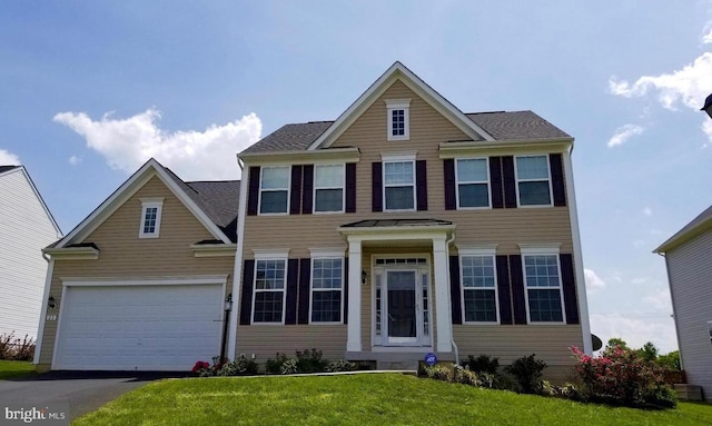 view of front of property with a front yard and a garage