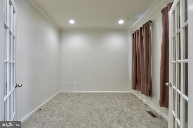 carpeted empty room featuring ornamental molding and french doors