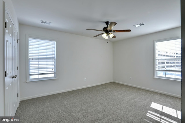 carpeted empty room with ceiling fan and a healthy amount of sunlight