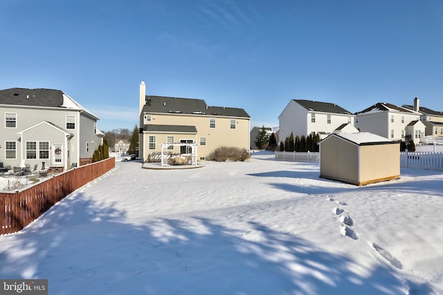 view of snow covered back of property