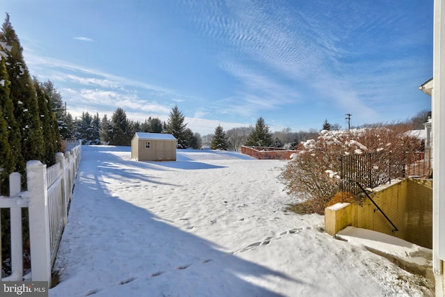 yard covered in snow featuring a shed