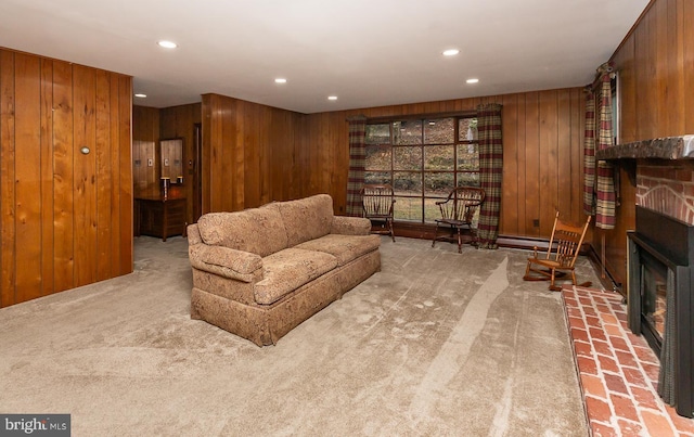 sitting room featuring a brick fireplace, light colored carpet, and wooden walls