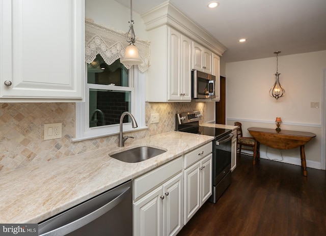 kitchen with sink, stainless steel appliances, white cabinets, dark hardwood / wood-style flooring, and decorative light fixtures