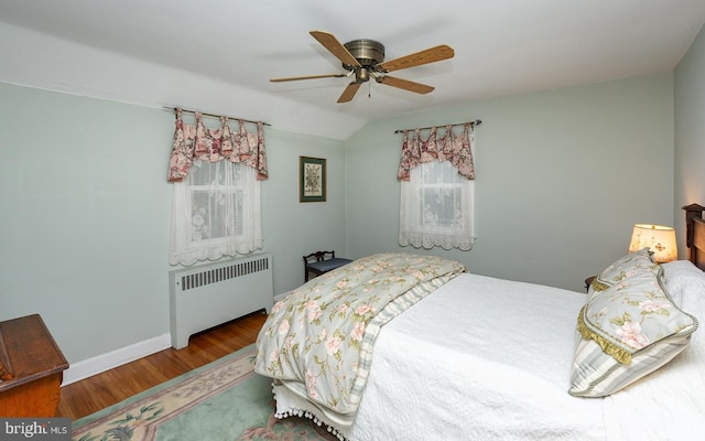 bedroom with ceiling fan, lofted ceiling, radiator heating unit, and wood-type flooring