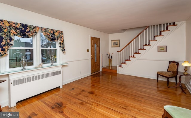 entrance foyer featuring wood-type flooring and radiator heating unit