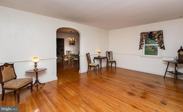 living area with an inviting chandelier and wood-type flooring