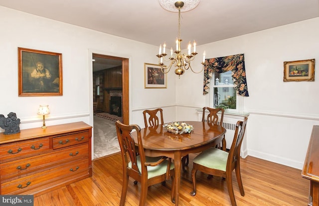 dining room featuring a fireplace and light hardwood / wood-style flooring