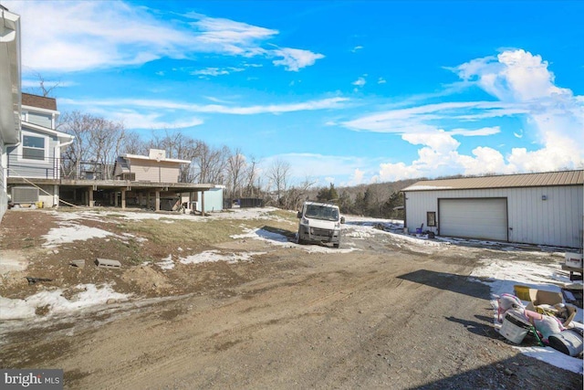 view of yard featuring a garage and an outbuilding