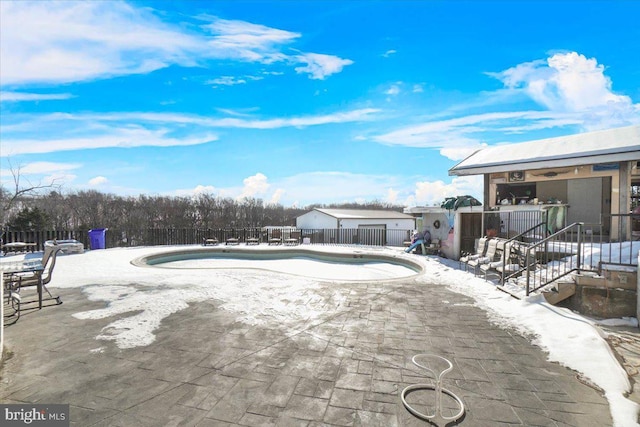 snow covered pool with a patio area