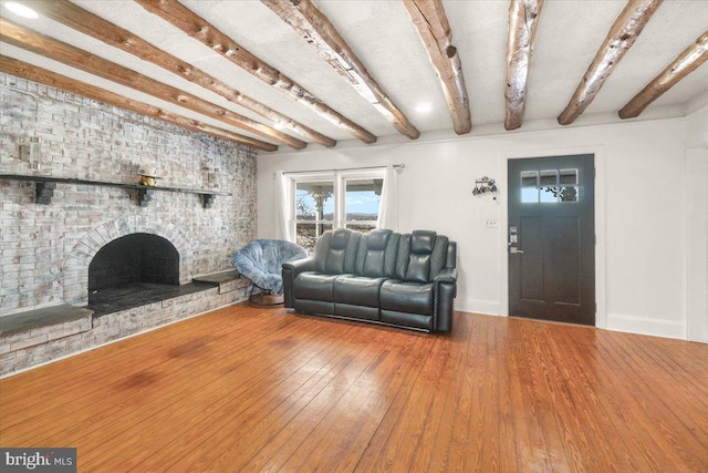 living room featuring a fireplace, hardwood / wood-style flooring, and beamed ceiling