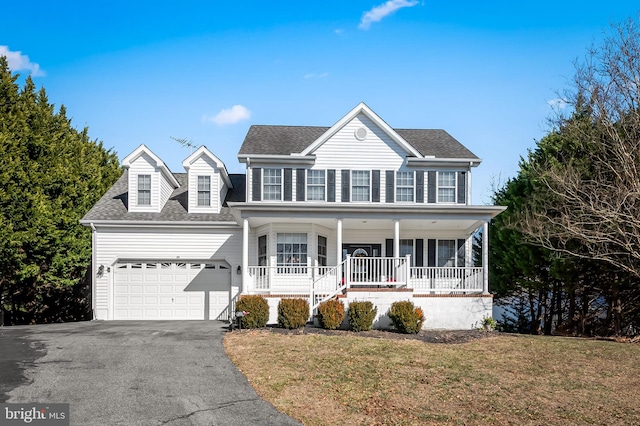 view of front of home featuring a porch, a garage, and a front yard