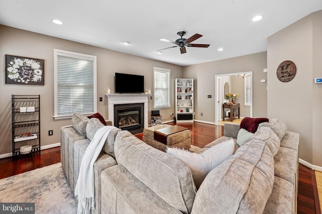 living room featuring dark wood-type flooring and ceiling fan