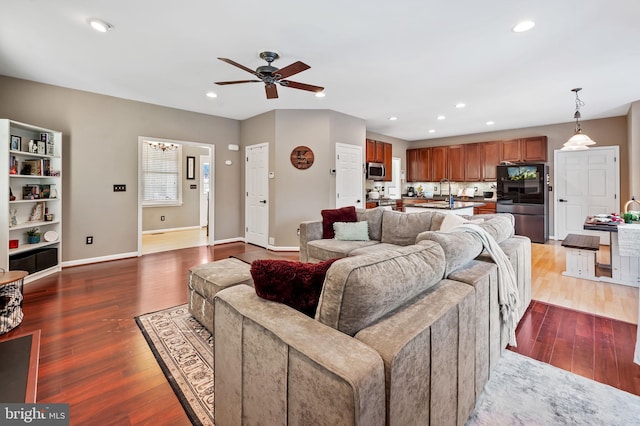 living room featuring ceiling fan, sink, and hardwood / wood-style floors