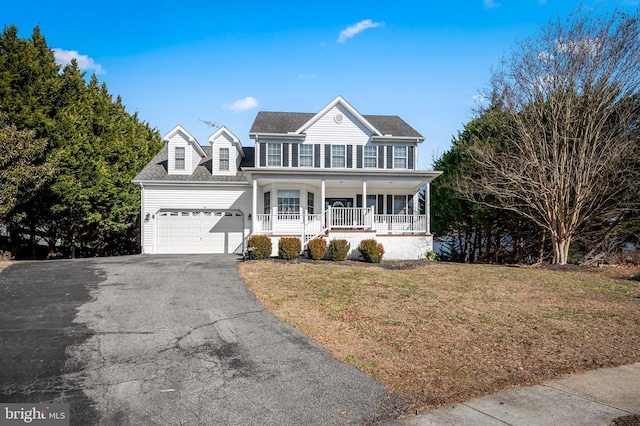 view of front of house with a garage, covered porch, and a front yard