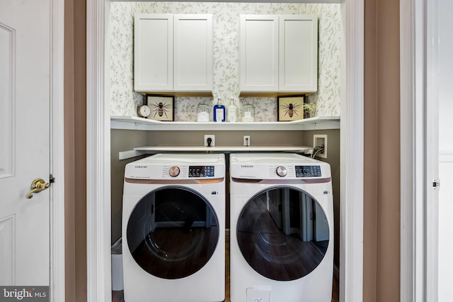 laundry room with washer and clothes dryer and cabinets