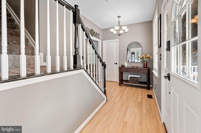 foyer with a notable chandelier and light hardwood / wood-style floors