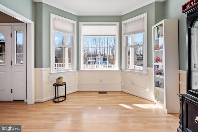 interior space with crown molding and light hardwood / wood-style floors