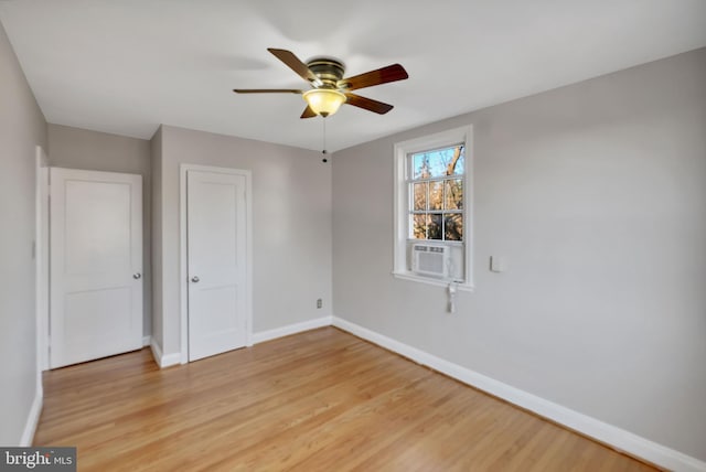 empty room featuring hardwood / wood-style flooring, cooling unit, and ceiling fan