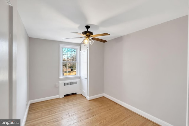 spare room with ceiling fan, radiator, and light hardwood / wood-style floors