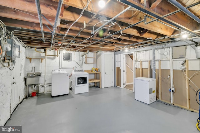 basement featuring fridge, sink, and washer and clothes dryer