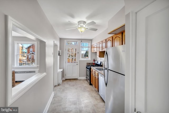 kitchen with appliances with stainless steel finishes, radiator heating unit, and ceiling fan