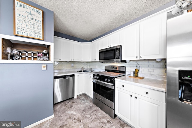 kitchen featuring a textured ceiling, stainless steel appliances, and white cabinets