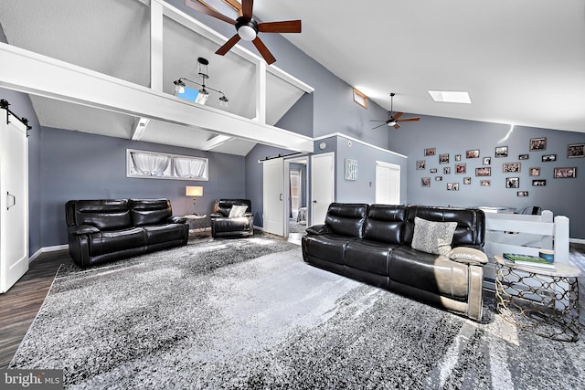 living room featuring dark wood-type flooring, ceiling fan, a barn door, and lofted ceiling with skylight