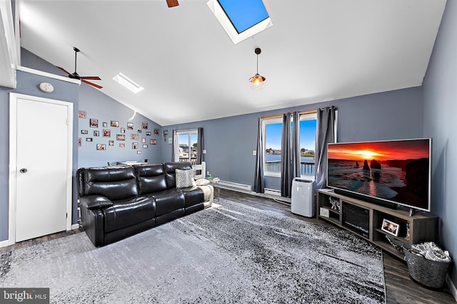 living room featuring ceiling fan, lofted ceiling with skylight, and dark wood-type flooring