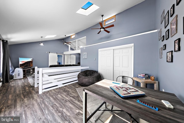 dining space featuring ceiling fan, a skylight, hardwood / wood-style flooring, and high vaulted ceiling