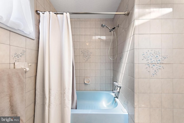 bathroom with a textured ceiling and shower / bath combo