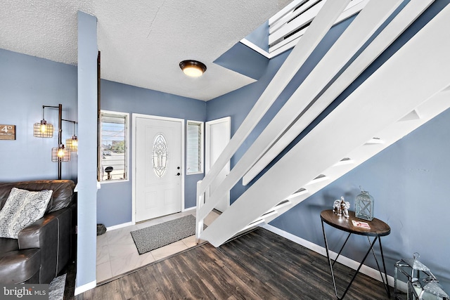 entryway with hardwood / wood-style flooring and a textured ceiling