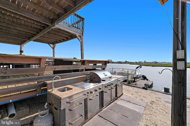 view of patio featuring grilling area, sink, and a water view