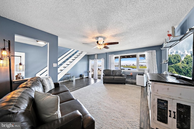 living room featuring a textured ceiling, ceiling fan, and dark hardwood / wood-style floors