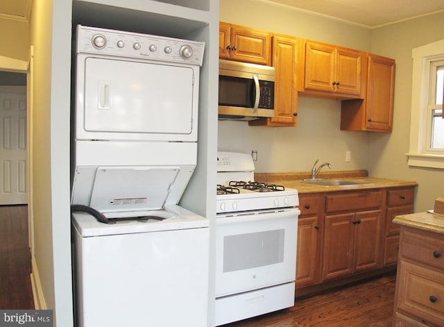 kitchen with stacked washer and dryer, sink, dark hardwood / wood-style floors, and white gas range